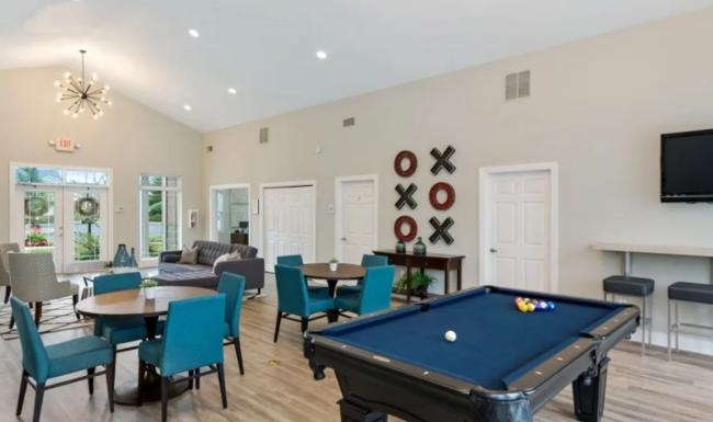 a room with a pool table and chairs