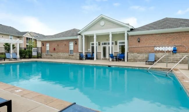 a swimming pool with a house in the background